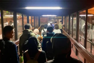 Puluhan penumpang melintasi jembatan garbarata untuk memasuki pesawat