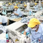 Para pekerja sedang menjahit di sebuah pabrik garmen