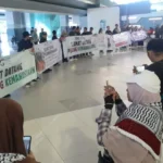 Sejumlah aktivis kemanusiaan dan awak media membentangkan banner sambut kedatangan sembilan Warga Negara Indonesia peserta misi kemanusiaan Global Sumud Flotilla