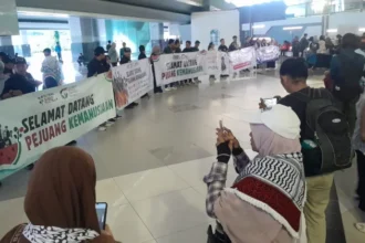 Sejumlah aktivis kemanusiaan dan awak media membentangkan banner sambut kedatangan sembilan Warga Negara Indonesia peserta misi kemanusiaan Global Sumud Flotilla