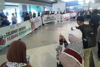 Sejumlah aktivis kemanusiaan dan awak media membentangkan banner sambut kedatangan sembilan Warga Negara Indonesia peserta misi kemanusiaan Global Sumud Flotilla