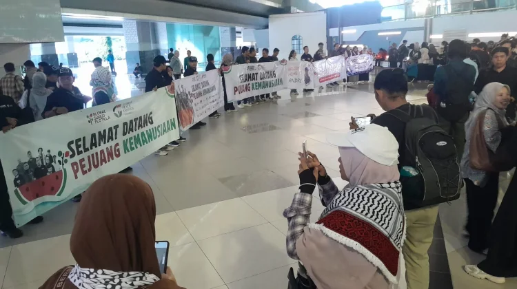 Sejumlah aktivis kemanusiaan dan awak media membentangkan banner sambut kedatangan sembilan Warga Negara Indonesia peserta misi kemanusiaan Global Sumud Flotilla