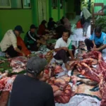 Sejumlah petugas sedang memotong dan mengemas daging kurban saat momen Iduladha di MTsN 1 Banyuwangi tahun 2025